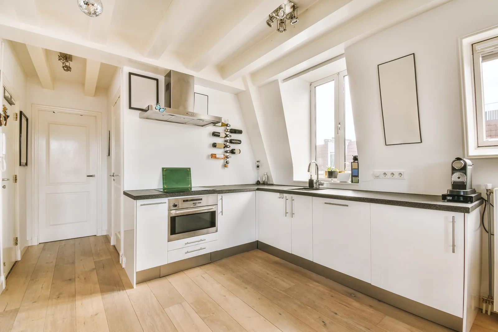 Bright kitchen with white painted cabinets and wood floors