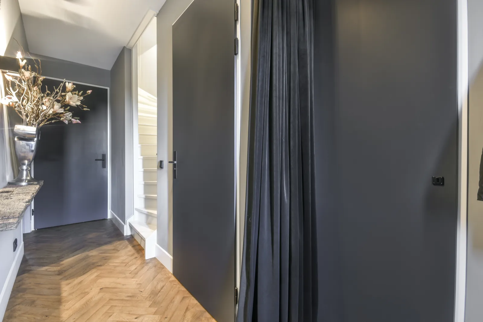Long freshly painted corridor with doors and wood flooring