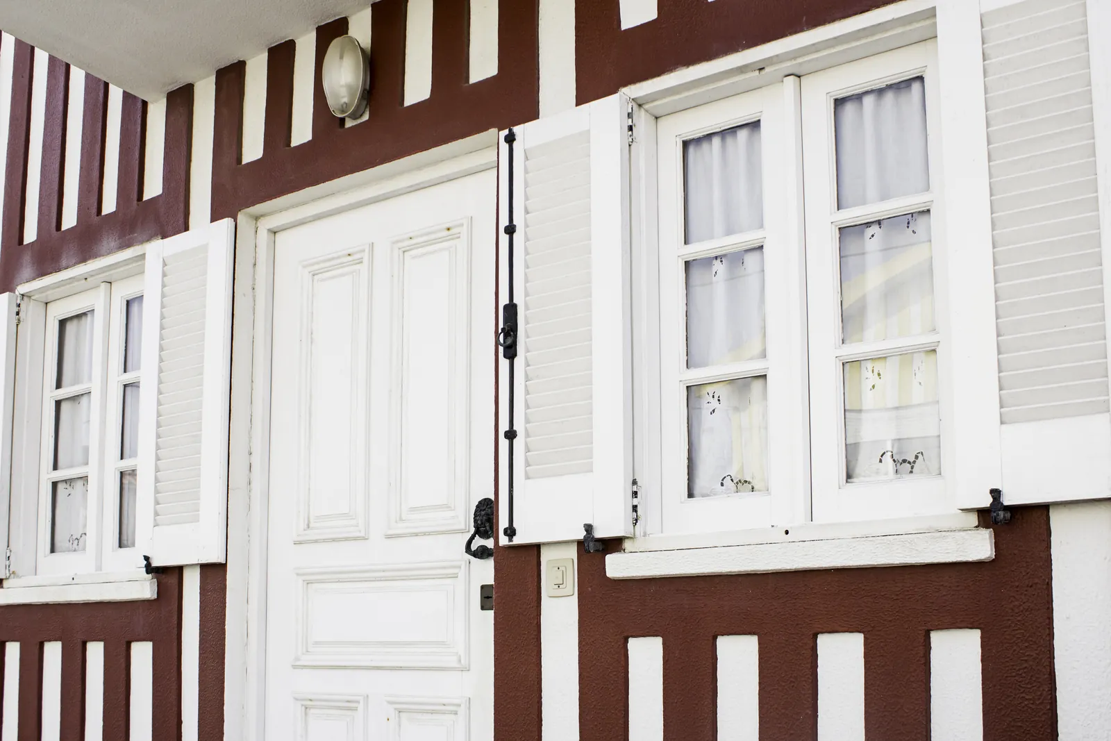 House facade with a white front door and shutters