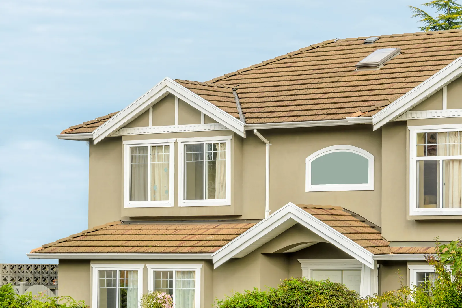 Tan two-storey home with white windows and trim