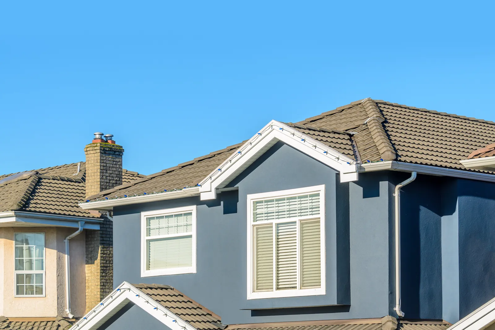 Suburban home with blue lap siding and a tiled roof